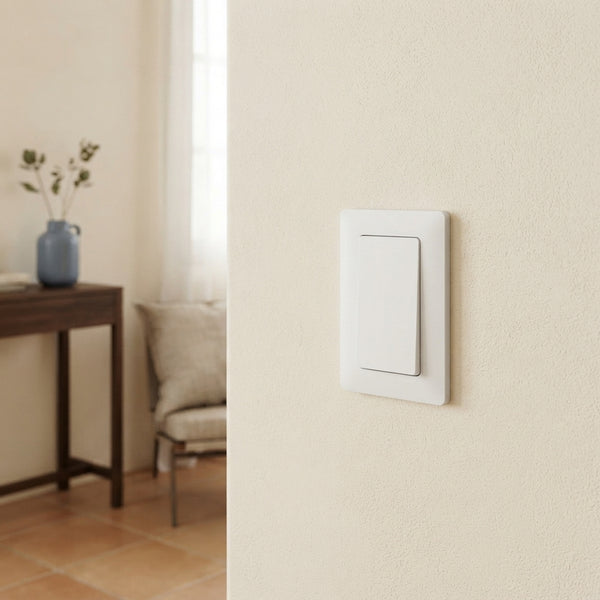 Sleek remote light switch mounted on a cream wall in a minimalist modern home interior.