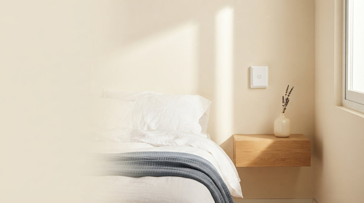 A modern remote light switch mounted on a bedroom wall in a bright, minimalist home interior with soft natural lighting.